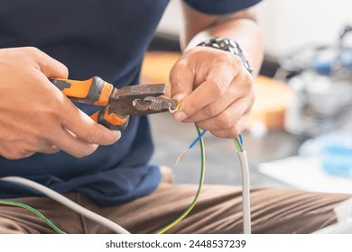 Technician man connecting electric wires with pliers to install new air conditioning, repair service, and install new air conditioner concepts