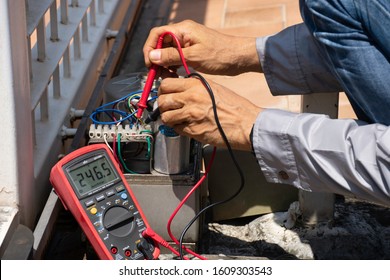 Technician man hand using digital multimeter and checking the functional of auto door. Maintenance and repairing automatic gate concept. service concept. 