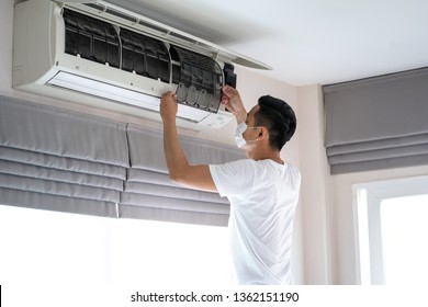 Technician Man Repairing ,cleaning And Maintenance Air Conditioner On The Wall In Bedroom.On Site Home Service,Business ,Industrial Concept.