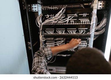 Technician managing network cables in a server room during the afternoon hours - Powered by Shutterstock - Get 15% off with code: PIKWIZARD15