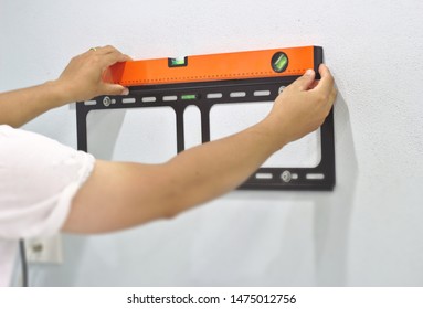 Technician To Measure Water Level Of The TV Mounting Device On The Wall Installation Of Steel Plates With TV For Weight Loss