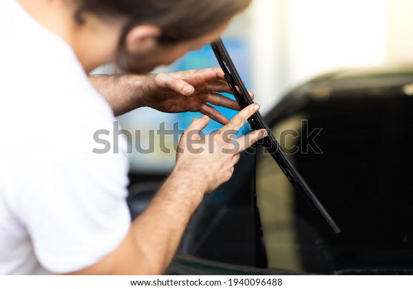 Technician\
and mechanical changing windscreen wipers on a car station. Car\
maintenance and auto service garage concept.\
