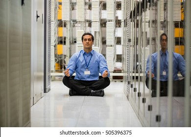 Technician meditating in hallway of server room - Powered by Shutterstock