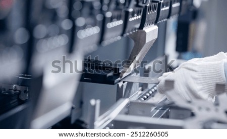 Technician operator working on automatic hydraulic press for bending metal sheets in industrial production.