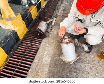 Technician performing preventive maintenance and reassembling an industrial oil filter at an oil and gas processing facility. The image illustrates equipment servicing, mechanical inspection, and industrial reliability in the field.