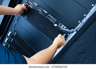A technician performs maintenance on a server in a modern data center, showcasing the intricate work involved in managing advanced technology systems.