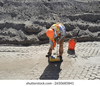 Technician performs nuclear density test using Troxler gauge to verify compaction on fine-grained fill at northern earthworks site during roadbed preparation.