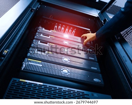 A technician performs server maintenance in a modern data center rack, ensuring optimal performance and connectivity for vital computing equipment.