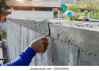 The technician is plastering the edge of the column to mold the corner of the column at 90 degrees. - Shutterstock ID 2199150943