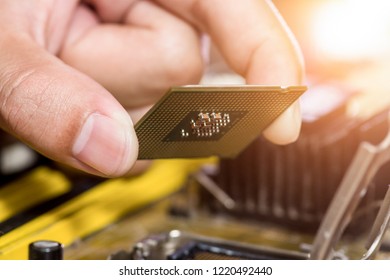 Technician plug in CPU microprocessor to motherboard socket - Shutterstock ID 1220492440
