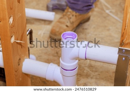 Technician plumber using glue is applied to plastic PVC pipes