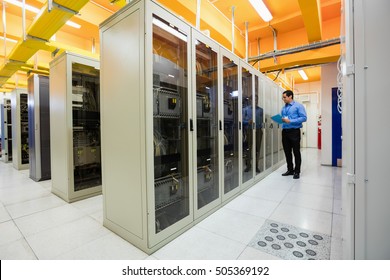 Technician preparing check list in server room