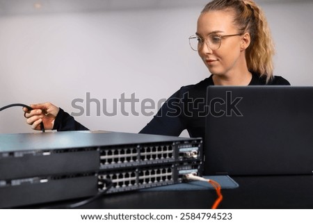 IT technician professional configuring network switch and managing network cables and hardware in a data center environment