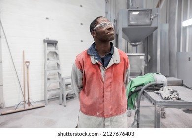 Technician in protective clothing standing in workshop - Shutterstock ID 2127676403