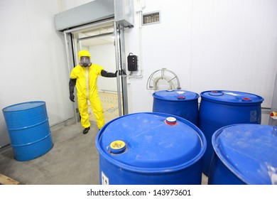 technician in protective uniform checking barrels with toxic substance in plant - Powered by Shutterstock