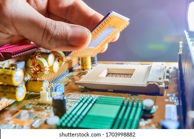 The technician is putting the CPU on the socket of the computer motherboard. Close up