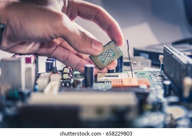 The technician is putting the CPU on the socket of the computer motherboard.
