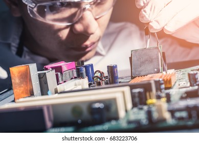 The technician is putting the CPU on the socket of the computer motherboard. the concept of computer hardware, repairing, upgrade and technology.
