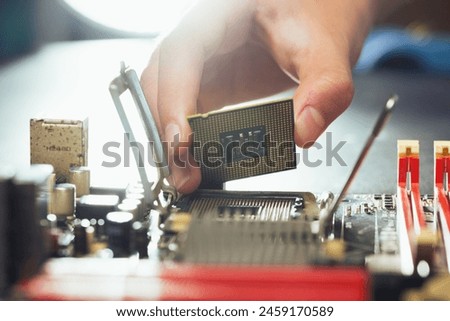 The technician is putting the CPU on the socket of the computer motherboard.