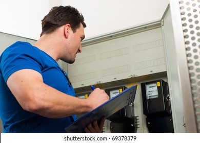 Technician Reading The Electricity Meter To Check Consumption