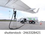 Technician is refueling aircraft with Sustainable Aviation Fuel (SAF)
