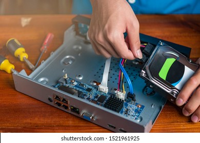 Technician remove a hard disk drive from the CCTV DVR recorder case , to install a new hard drive and upgrading to a Solid State Drive (SSD) in to surveillance DVR.
