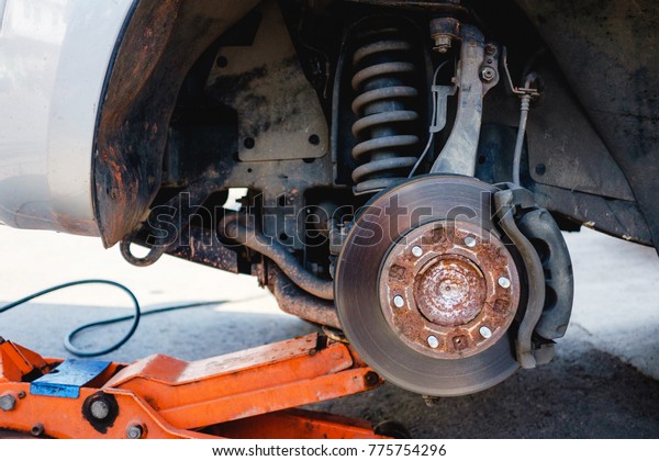 Technician remove a wheel to fix a broken Tired.\
He use a jack to lift up a car. Most of drivers check vehicle\
before take a trip on\
holiday.