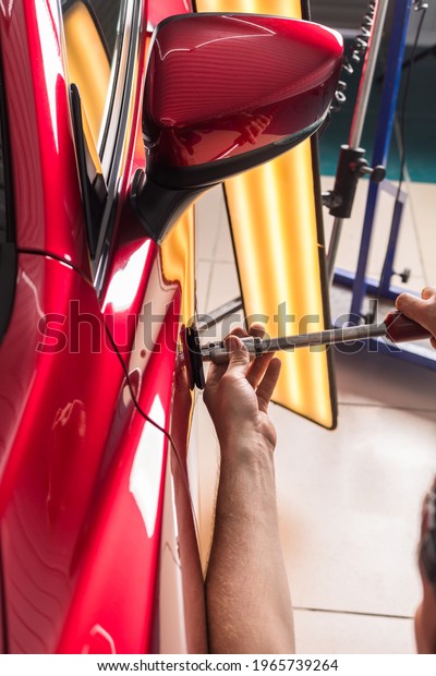 The technician removes\
dents on the car using the method without painting. PDR. Car body\
repair.