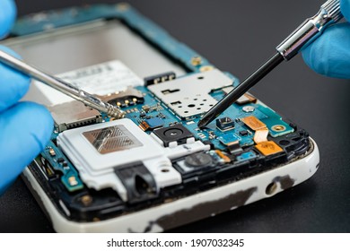 Techniker reparieren im Inneren des Mobiltelefons durch Löten von Eisen. Integrierter Schaltkreis. das Konzept von Daten, Hardware, Technologie.
