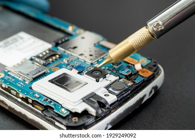 Techniker reparieren im Inneren des Mobiltelefons durch Löten von Eisen. Integrierter Schaltkreis. das Konzept von Daten, Hardware, Technologie.