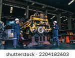 the technician repairing and inspecting the big diesel engine in the train garage
