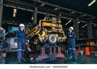 the technician repairing and inspecting the big diesel engine in the train garage