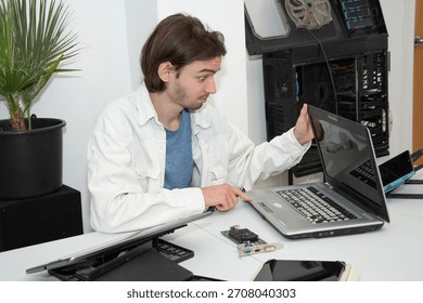 A technician repairs computer equipment using electronic components and tools. Electronics, hardware, workplace. sstkbusiness