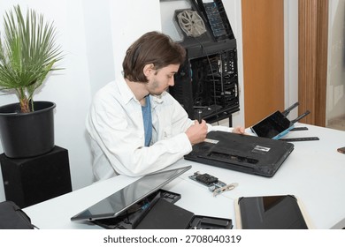 A technician repairs computer equipment using electronic components and tools. Electronics, hardware, workplace. sstkbusiness
