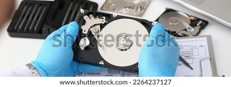 Technician repairs computer hard drive from motherboard