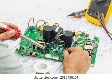 Technician repairs an electronics board using a soldering iron, surrounded by testing tools and schematics.