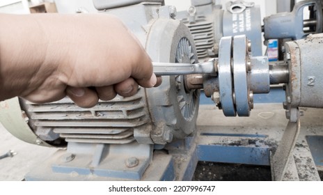 The Technician Repairs A Pulley Clutch On An Industrial Water Pump Motor.