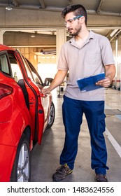 Technician With Safety Glasses Inspecting The Opening Of A Car Door In A Vehicle Inspection Workshop