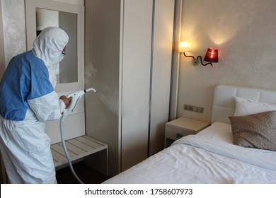 A Technician Is Sanitizing A Hotel Bedroom In Prague Against Covid 19, Using Steam And Ozone