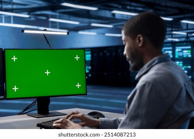 Technician in server hub ensuring data remains shielded from potential threats using green screen PC. Employee safeguarding data center hardware against malicious access with mockup computer display