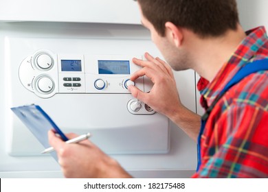 Technician Servicing The Gas Boiler For Hot Water And Heating