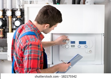 Technician Servicing The Gas Boiler For Hot Water And Heating