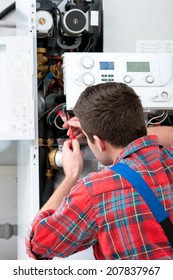 Technician Servicing The Gas Boiler For Hot Water And Heating