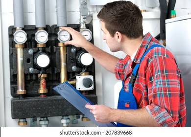 Technician Servicing The Gas Boiler For Hot Water And Heating