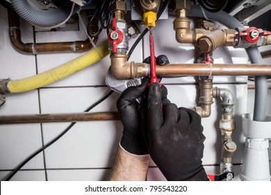 Technician servicing heating boiler

