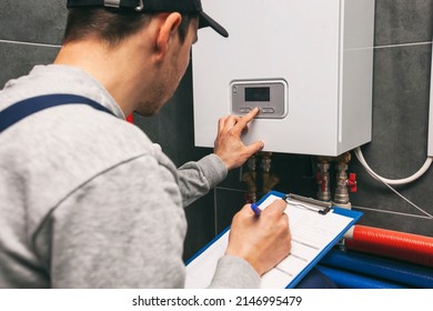Equipo técnico de mantenimiento portapapeles e inspección del sistema de calefacción en la sala de calderas