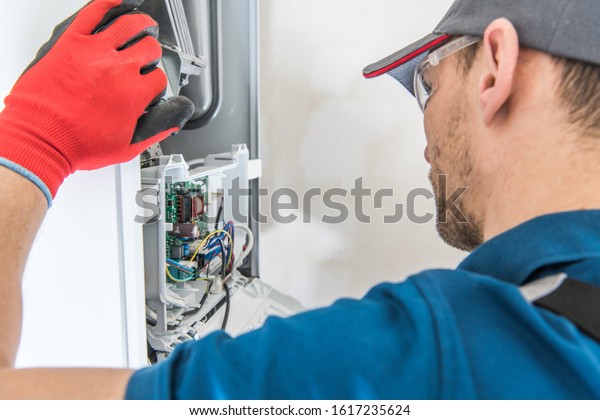Technician Servicing Residential Heating\
Equipment. Central Heat Gas Furnace Issue.\
\
\
\
\
