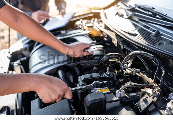 Technician team working of car\
mechanic in doing auto repair service and maintenance worker\
repairing vehicle with wrench, Service and Maintenance car\
check.