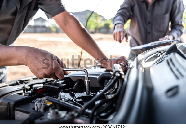 Technician team working of car
mechanic in doing auto repair service and maintenance worker
repairing vehicle with wrench, Service and Maintenance car
check.