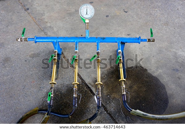 Technician use Pressure Testing tool for\
testing valve nozzle liquid petroleum fuel pumps gas station car\
service, Thailand - selective focus, soft\
focus